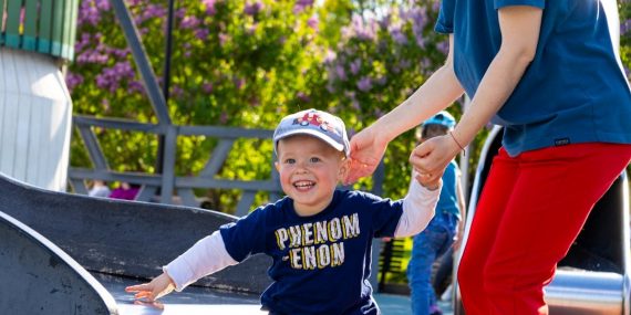 Happy child playing on a slide in a vibrant Russian park, enjoying a sunny day.